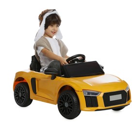 Photo of Cute little boy in pilot hat driving children's electric toy car on white background