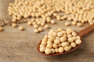 Photo of Natural soy beans on wooden table, closeup. Space for text