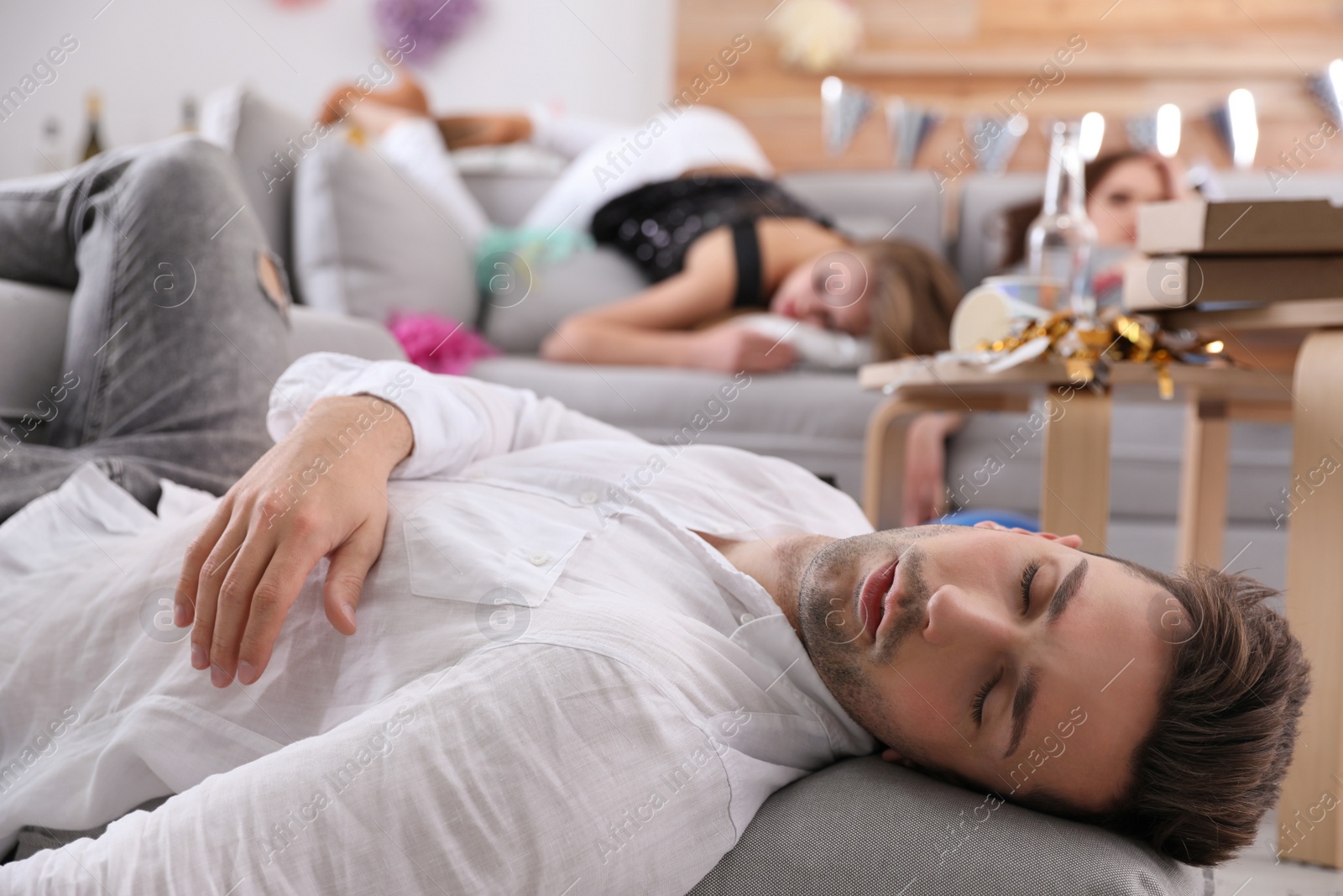 Photo of Young man sleeping in messy room after party