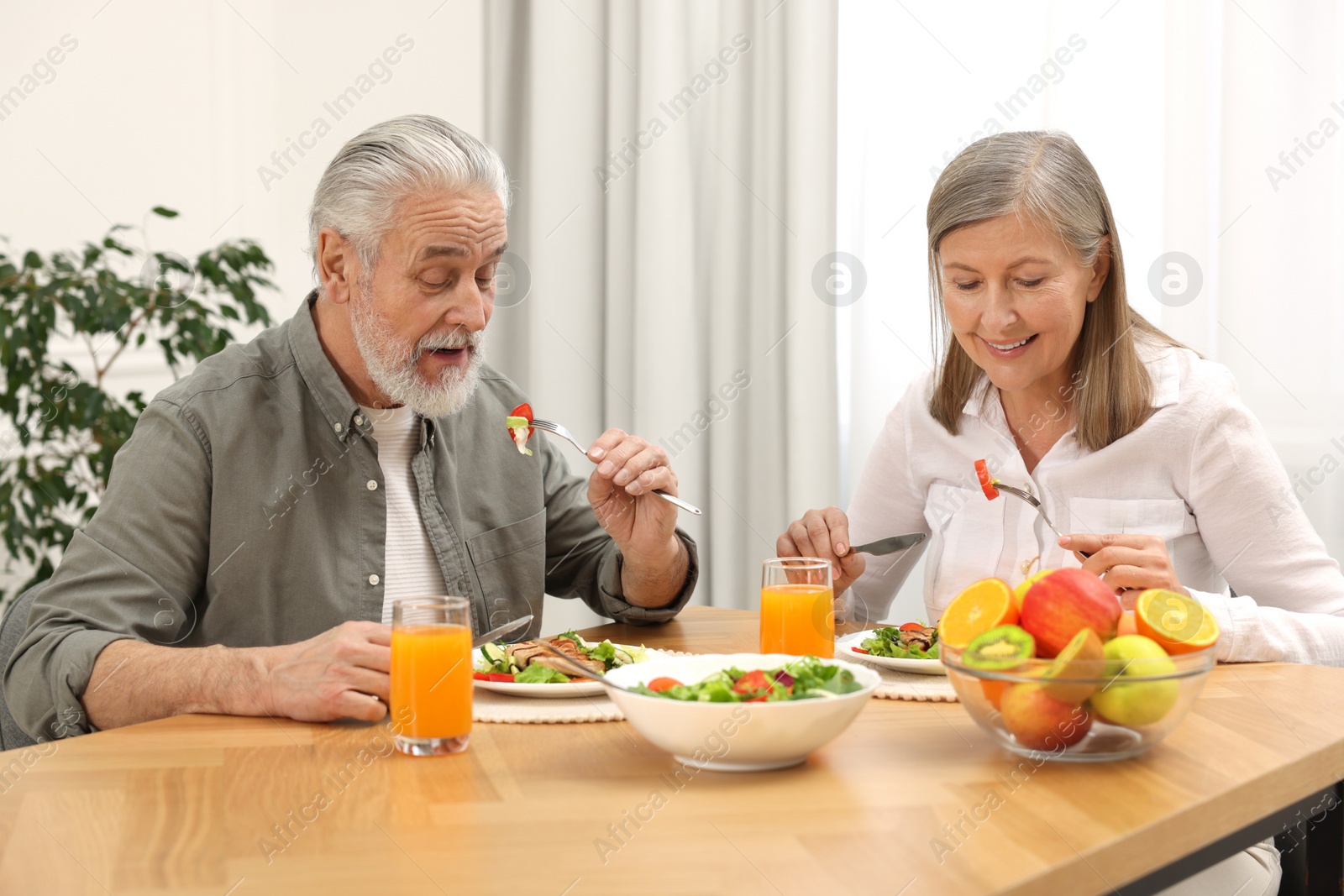 Photo of Happy senior couple having dinner at home