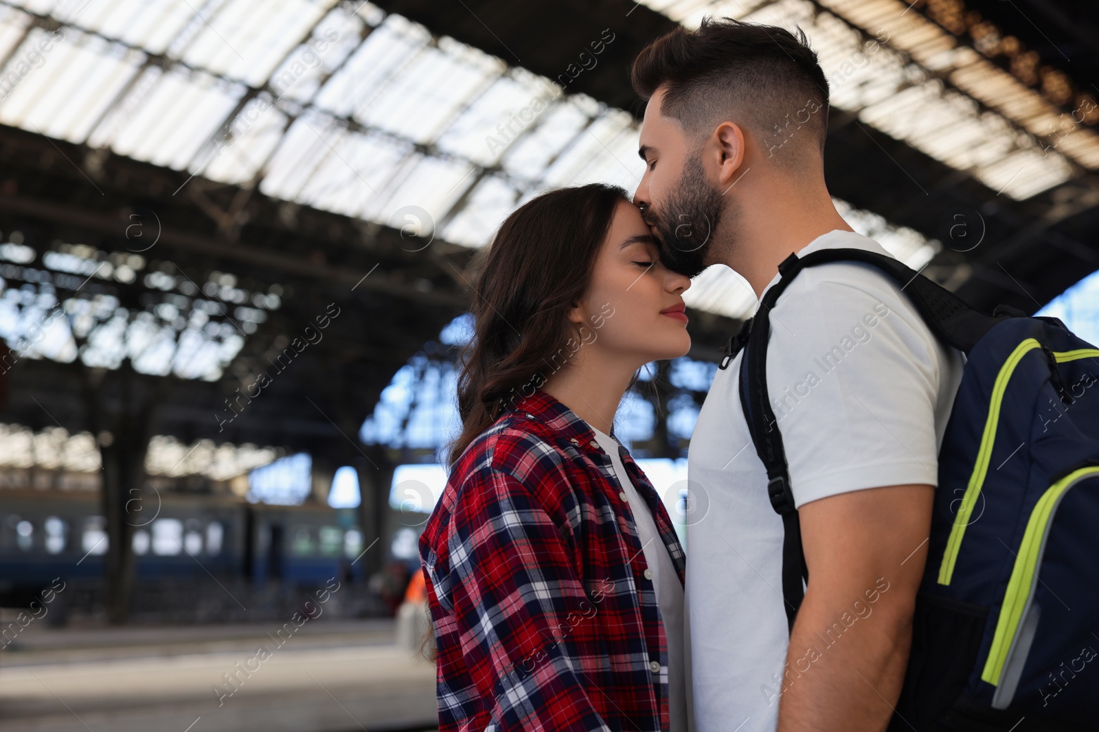 Photo of Long-distance relationship. Beautiful couple on platform of railway station, space for text