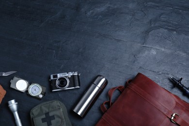 Photo of Flat lay composition with leather tourist backpack and camping equipment on black background, space for text