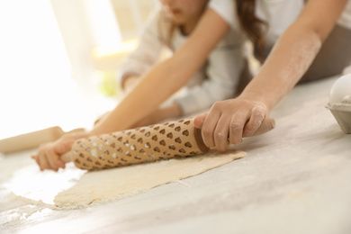 Photo of Cute little children cooking dough together in kitchen, closeup