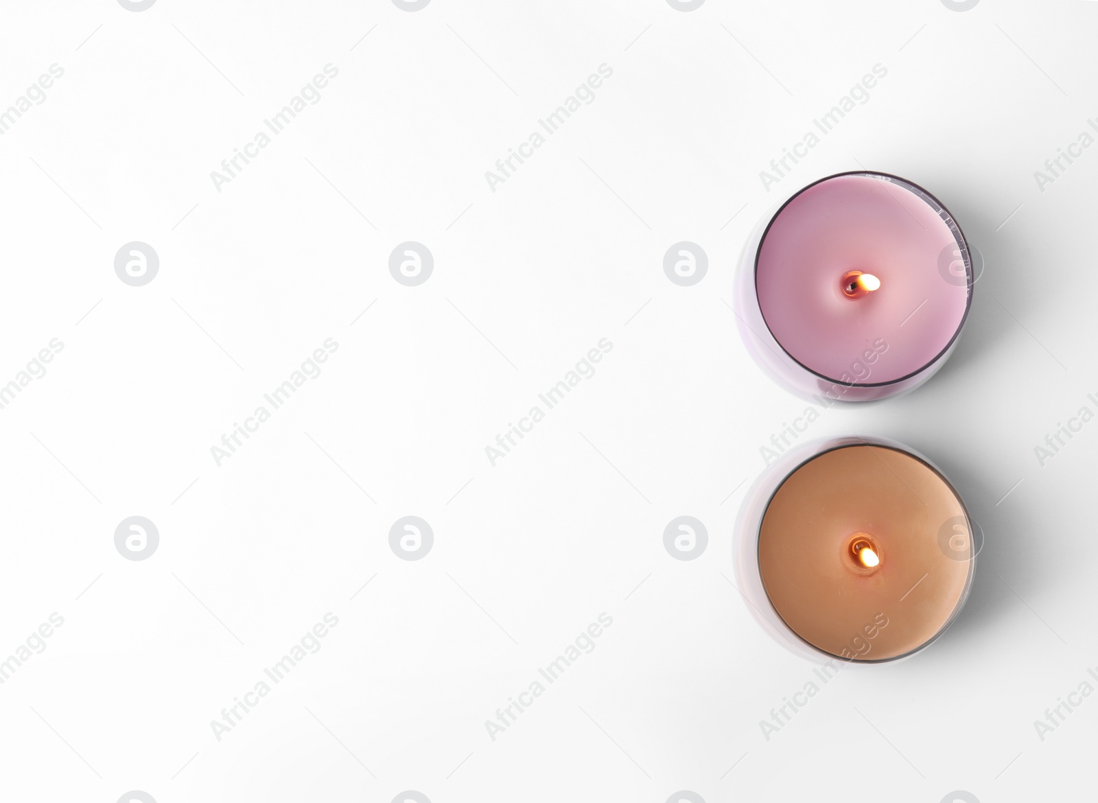 Photo of Color wax candles in glass holders isolated on white, top view