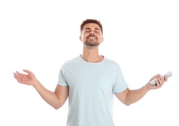 Photo of Happy young man with air conditioner remote control on white background