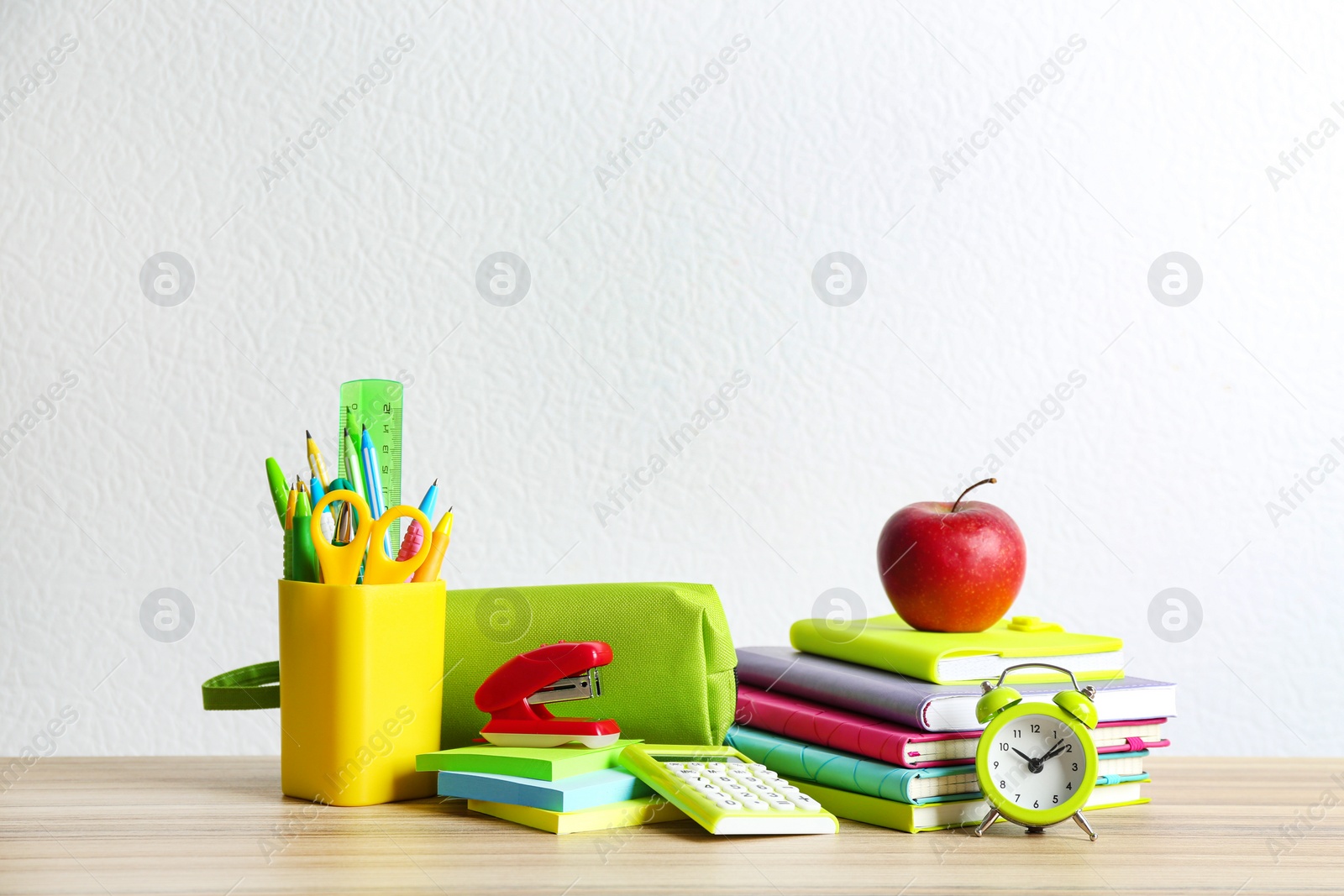 Photo of Different school stationery on wooden table against white background