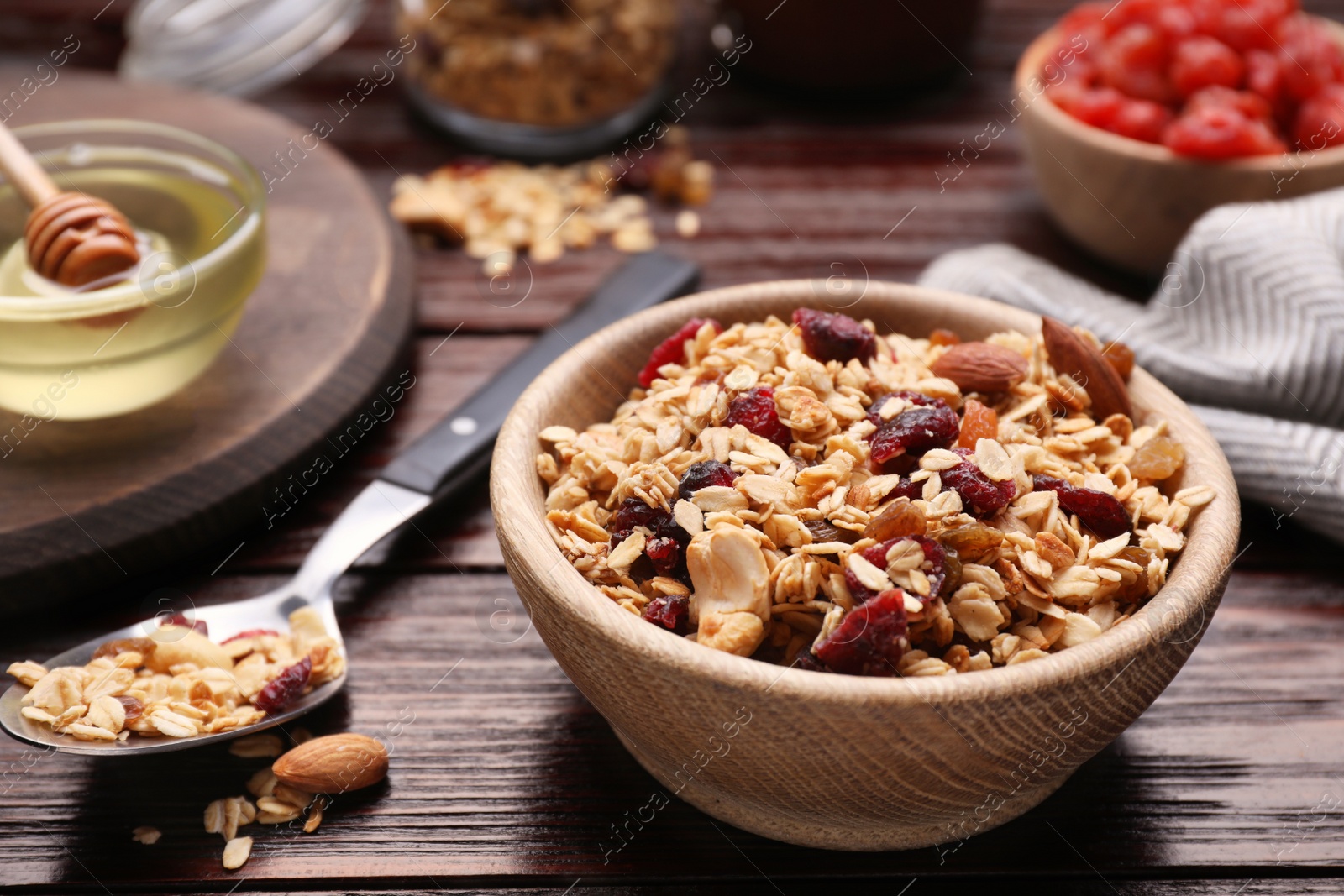 Photo of Tasty granola served with nuts and dry fruits on wooden table