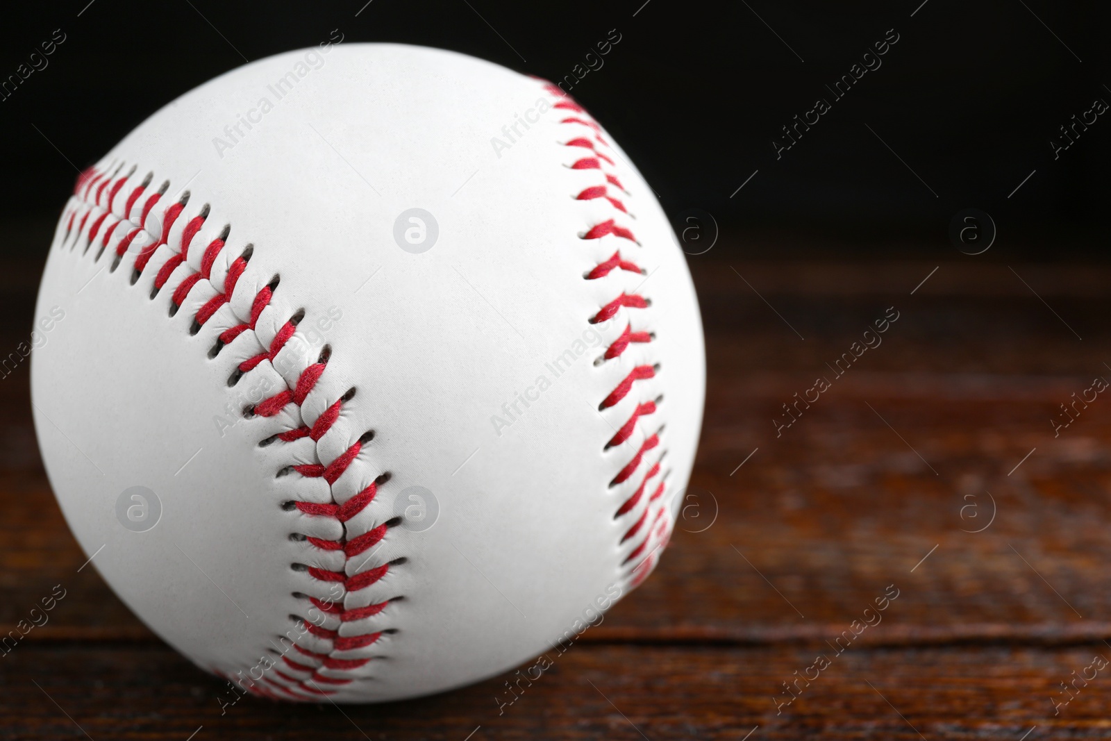 Photo of Baseball ball on wooden table, closeup with space for text. Sportive equipment