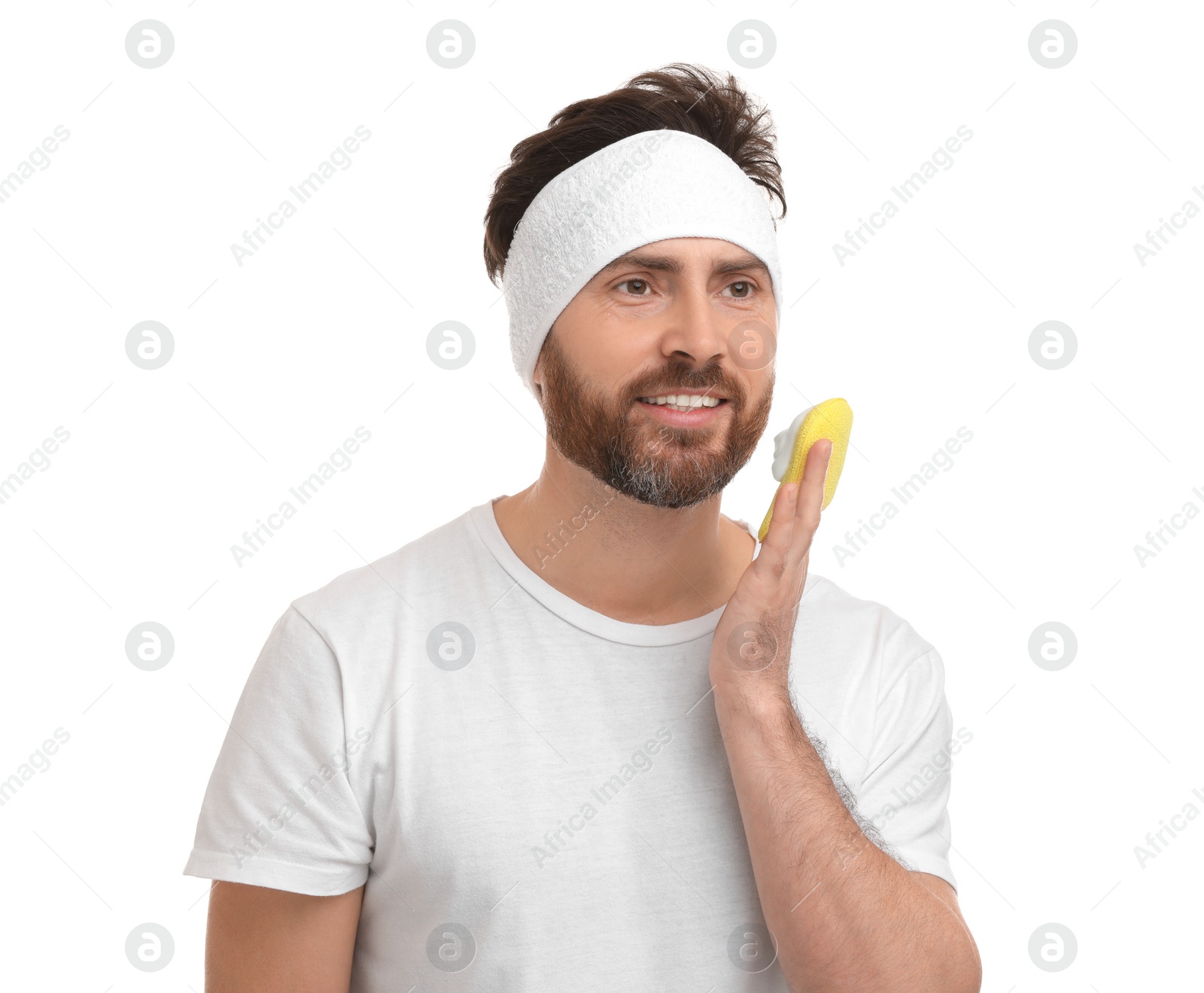 Photo of Man with headband washing his face using sponge on white background