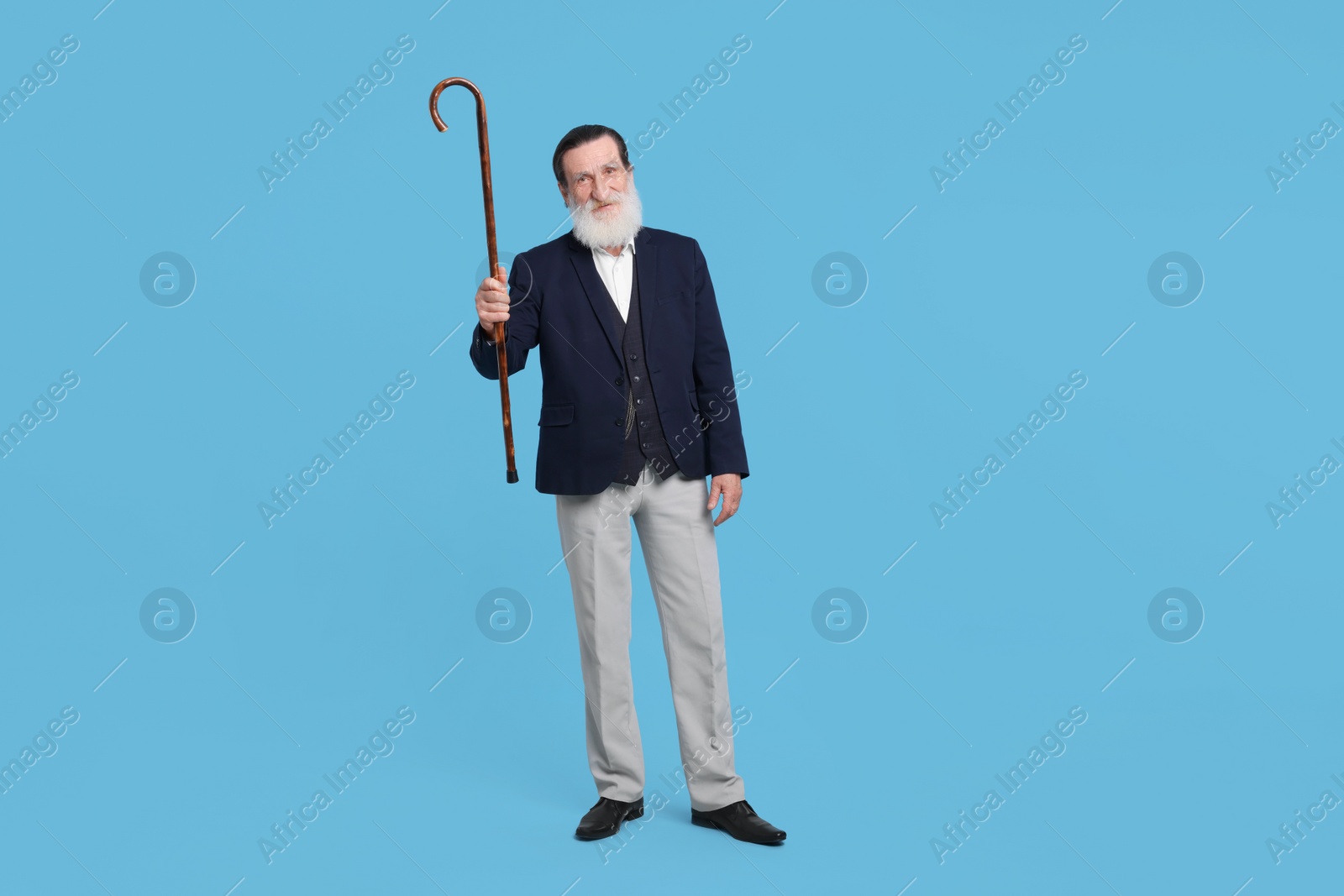 Photo of Senior man with walking cane on light blue background