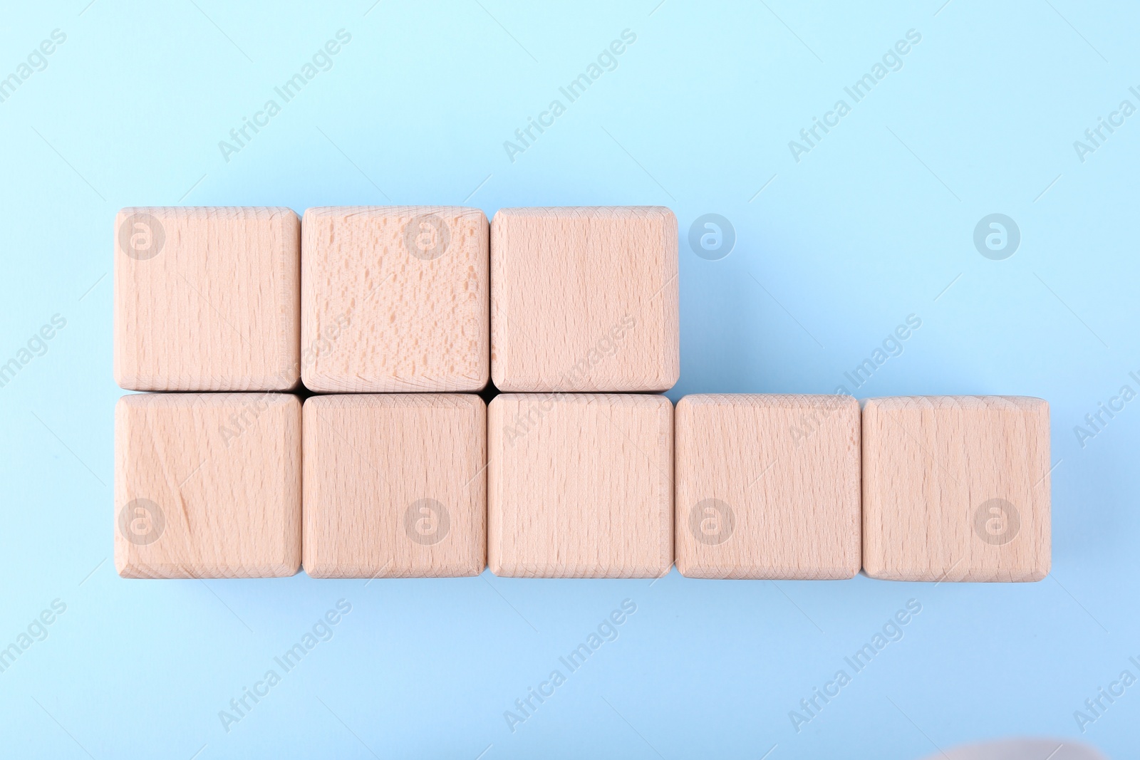 Photo of International Organization for Standardization. Wooden cubes with abbreviation ISO and number 18001 on light blue background, flat lay