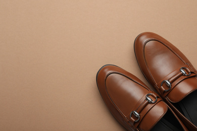 Pair of stylish male shoes on brown background, top view. Space for text