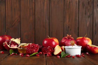 Photo of Honey, apples and pomegranate on wooden table. Rosh Hashanah holiday