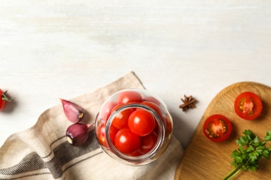 Photo of Pickling jar with fresh ripe cherry tomatoes and spices on white wooden table, flat lay. Space for text