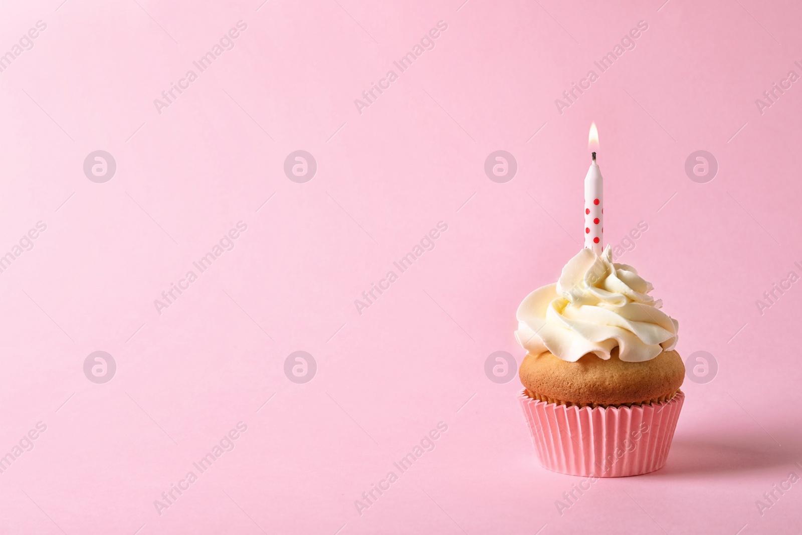 Photo of Delicious birthday cupcake with candle and space for text on color background