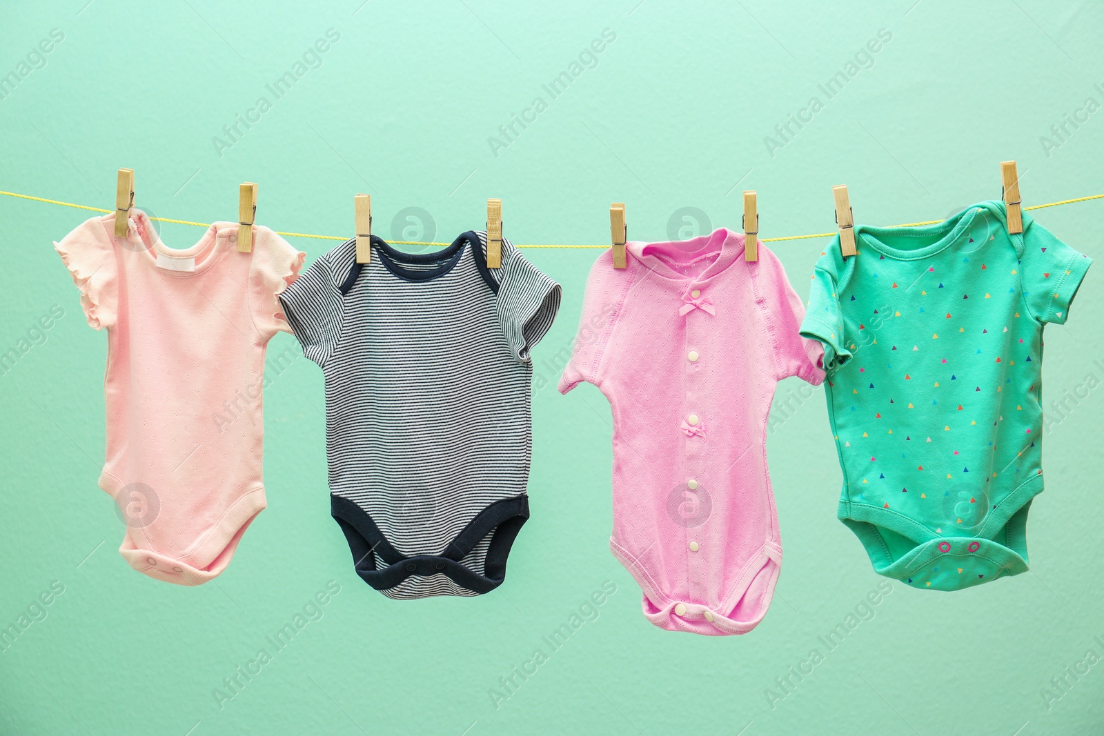 Photo of Children's clothes on laundry line against color background