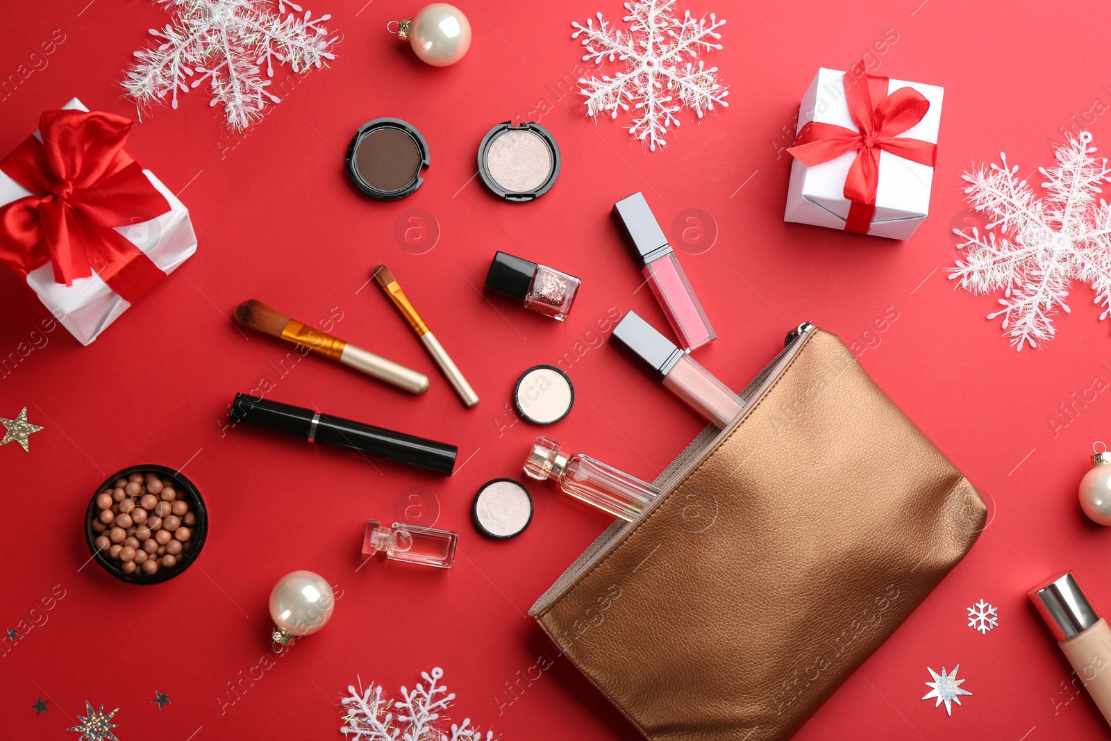 Photo of Flat lay composition with decorative cosmetic products on red background. Winter care