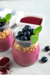 Image of Tasty dessert with acai smoothie, granola and berries on table, closeup