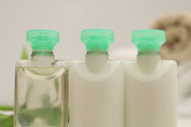 Photo of Mini bottles of cosmetic products on blurred background, closeup