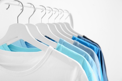 Photo of Men's clothes hanging on wardrobe rack against white background