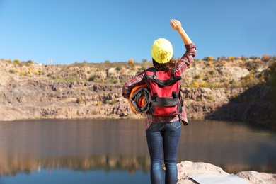 Female camper with sleeping bag near beautiful lake. Space for text