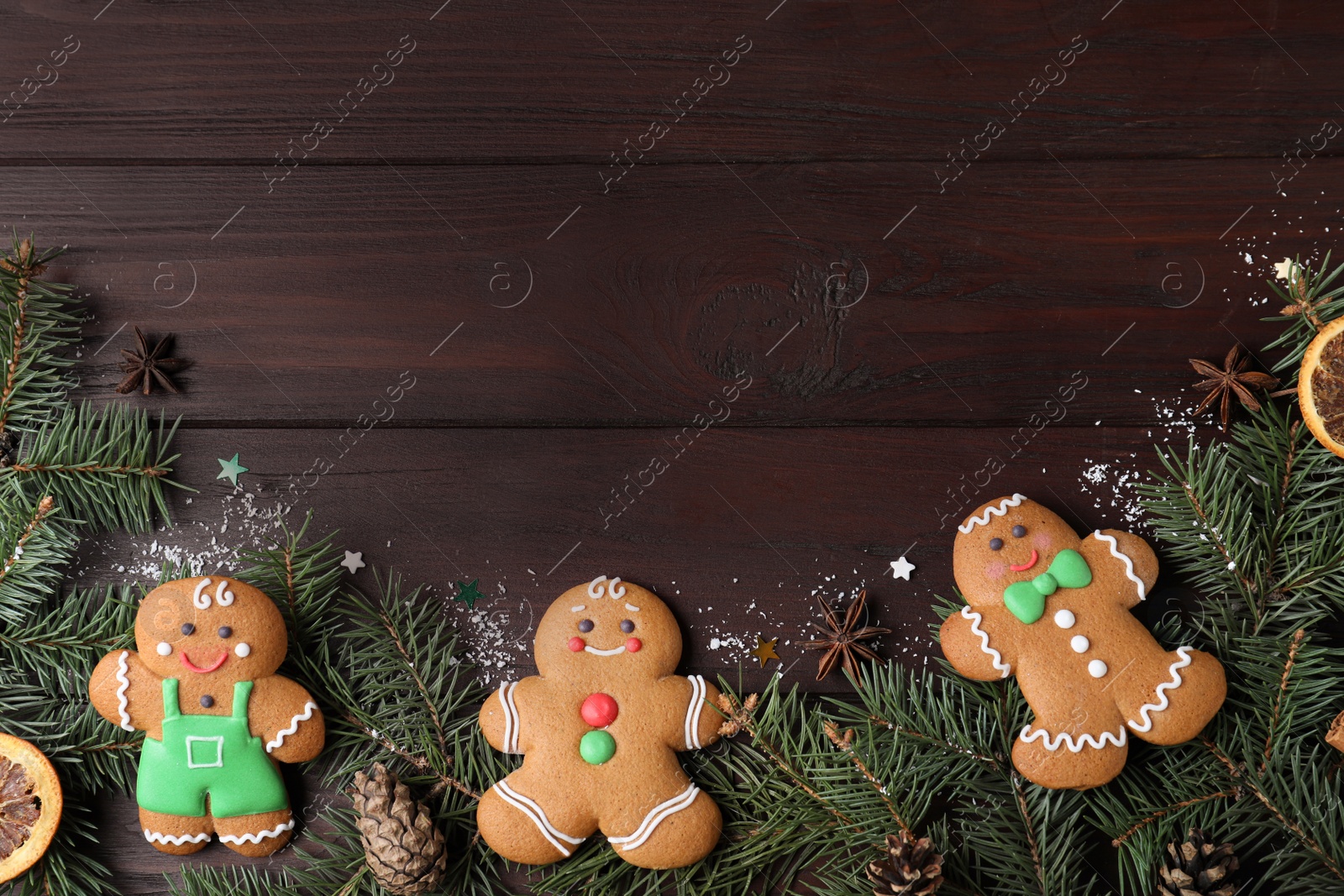 Photo of Decorated Christmas cookies and fir tree branches on wooden table, flat lay. Space for text