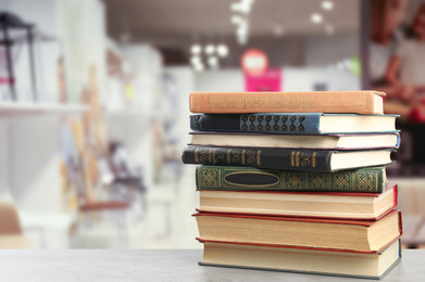 Image of Collection of different books on table against blurred background, space for text