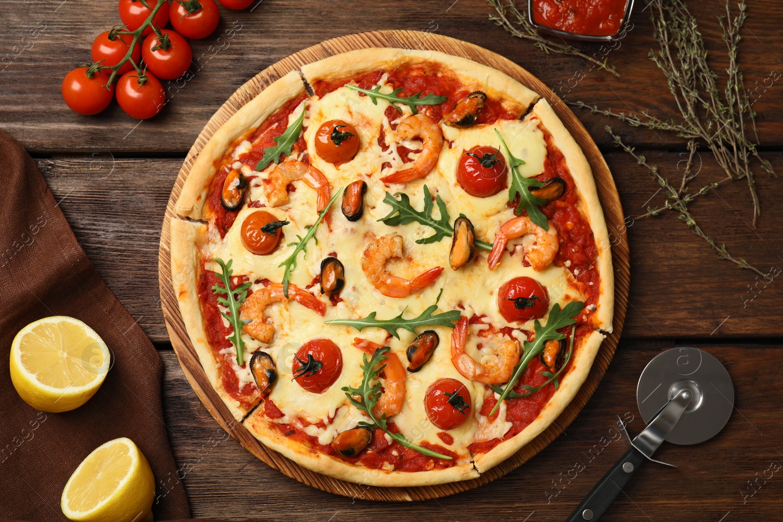 Photo of Delicious seafood pizza on wooden table, flat lay