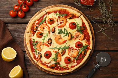 Photo of Delicious seafood pizza on wooden table, flat lay