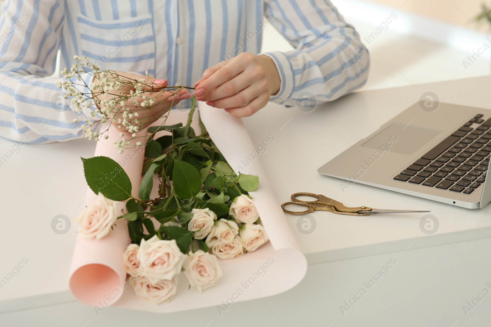 Photo of Woman making bouquet following online florist course at home, closeup. Time for hobby