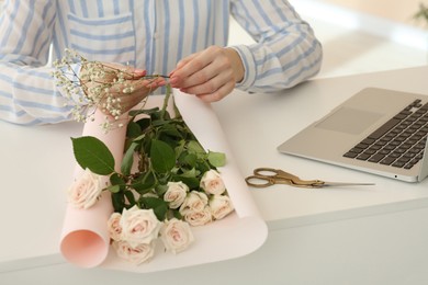 Photo of Woman making bouquet following online florist course at home, closeup. Time for hobby