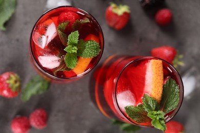 Delicious refreshing sangria and strawberries on grey table, flat lay