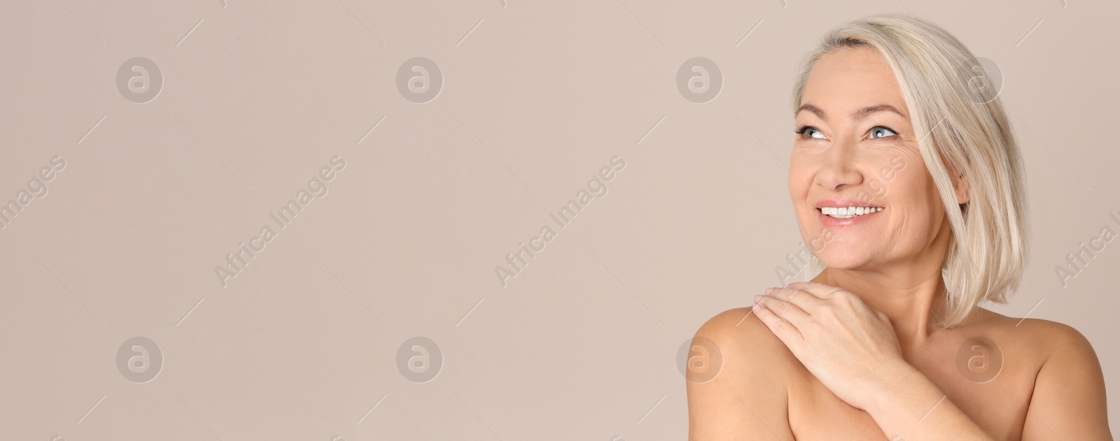 Image of Portrait of beautiful mature woman on beige background, space for text. Banner design