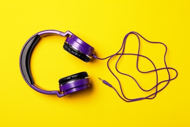 Stylish modern headphones on color background, top view