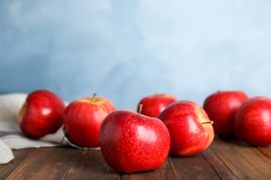 Photo of Ripe red apples on wooden table. Space for text