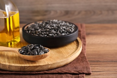 Photo of Sunflower seeds and oil on wooden table