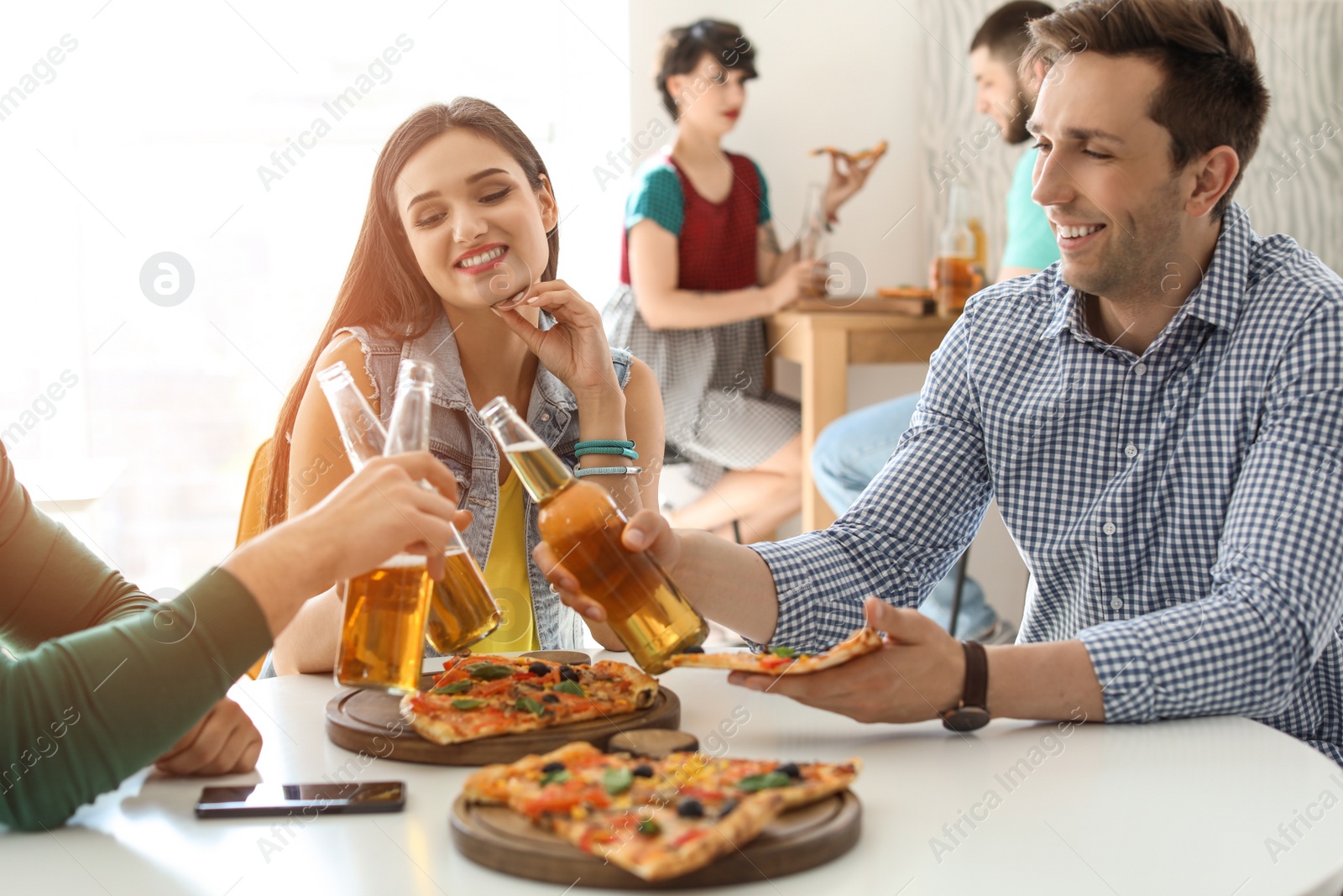 Photo of Young people having fun party with delicious pizza indoors