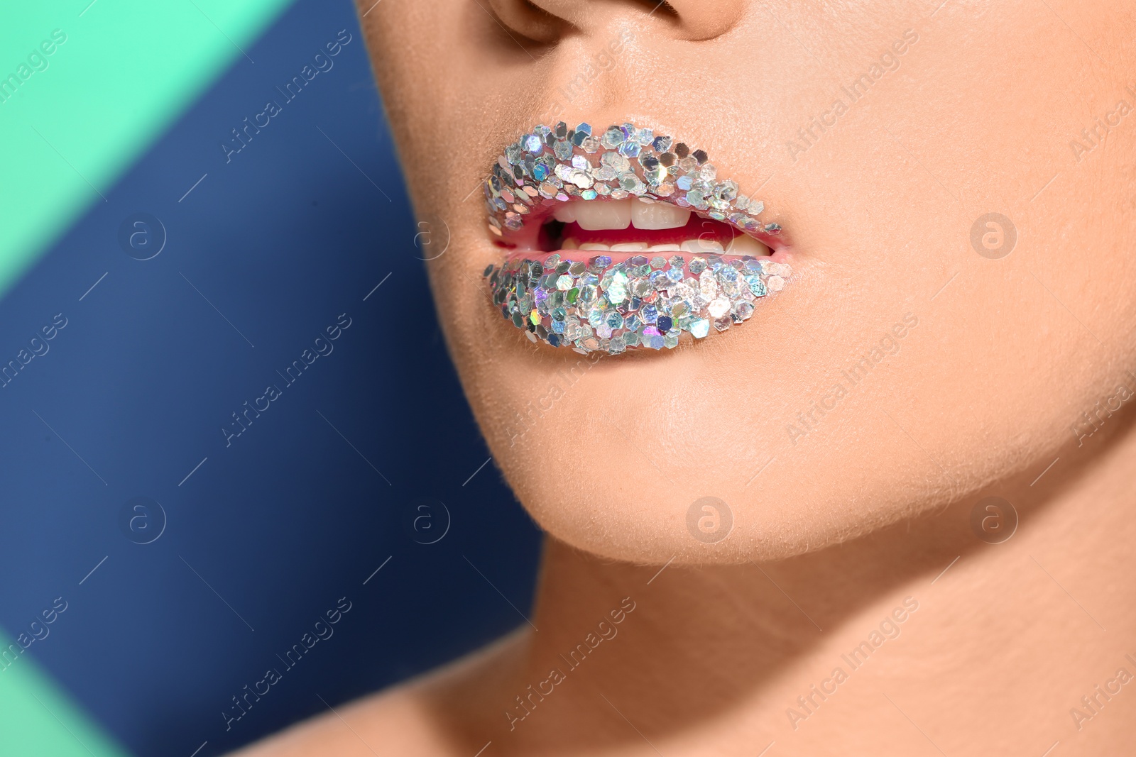 Photo of Beautiful young model with extravagant lips makeup on color background