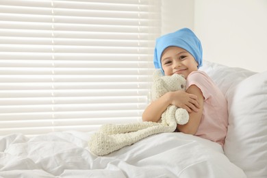 Photo of Childhood cancer. Girl hugging toy bunny in hospital