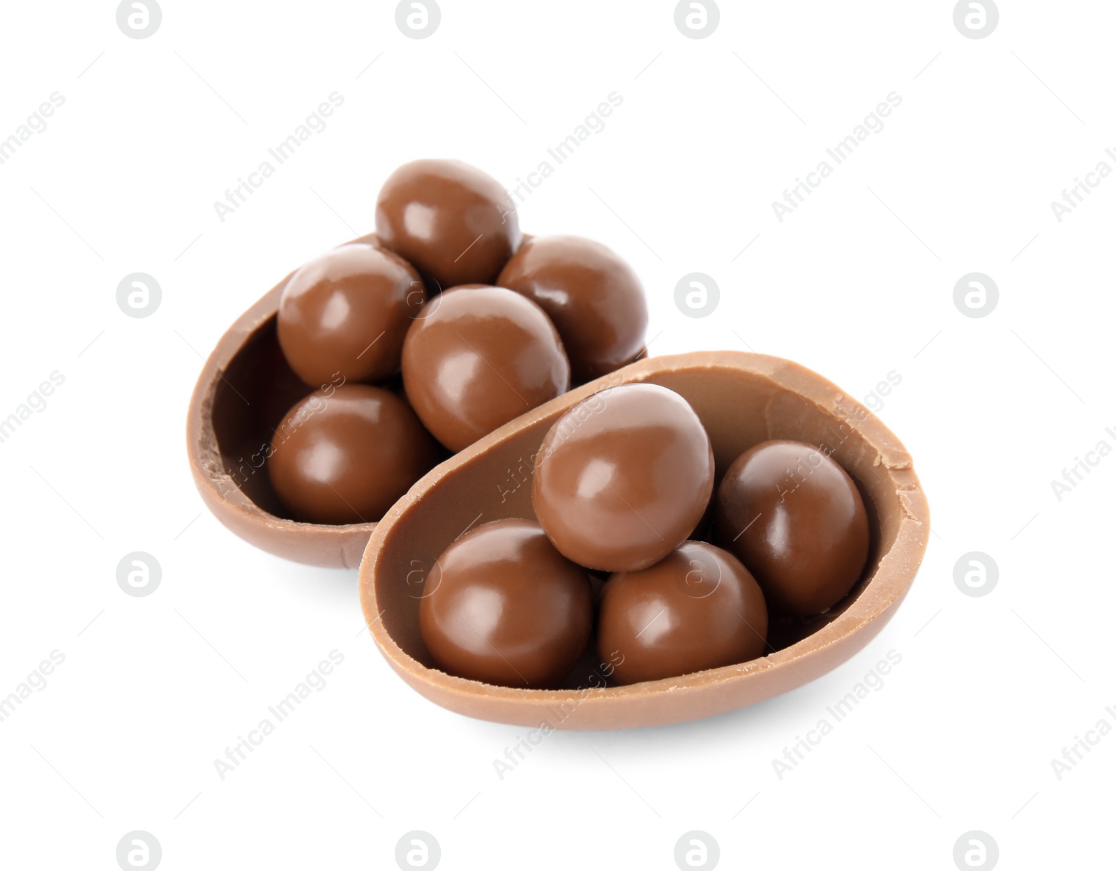 Photo of Halves of tasty chocolate egg with candies on white background