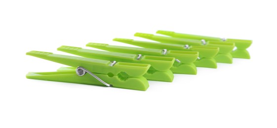 Photo of Bright green plastic clothespins on white background