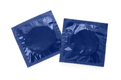 Photo of Packaged condoms on white background, top view. Safe sex