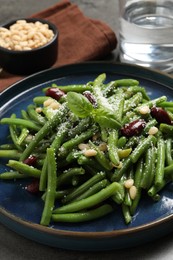 Photo of Plate of tasty salad with green beans on grey table