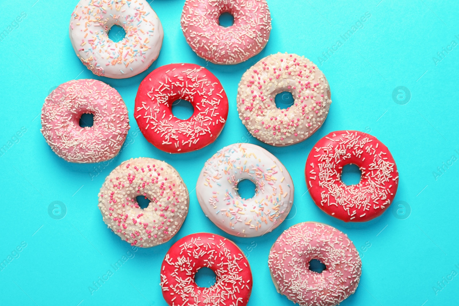 Photo of Delicious glazed doughnuts on color background, top view