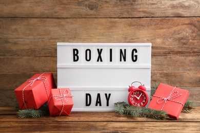 Composition with Boxing Day sign and Christmas gifts on wooden table