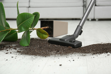 Removing soil from wooden floor with vacuum cleaner at home