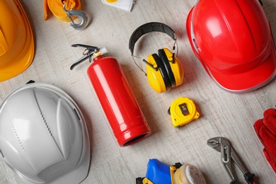 Photo of Flat lay composition with tools and safety equipment on wooden background