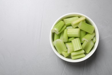 Fresh green cut celery on light grey table, top view. Space for text