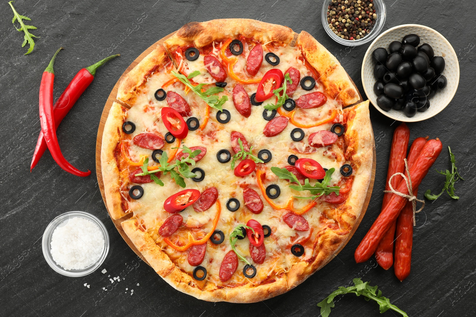 Photo of Tasty pizza and ingredients on grey table, top view