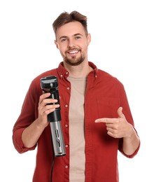 Photo of Smiling man pointing on sous vide cooker against white background